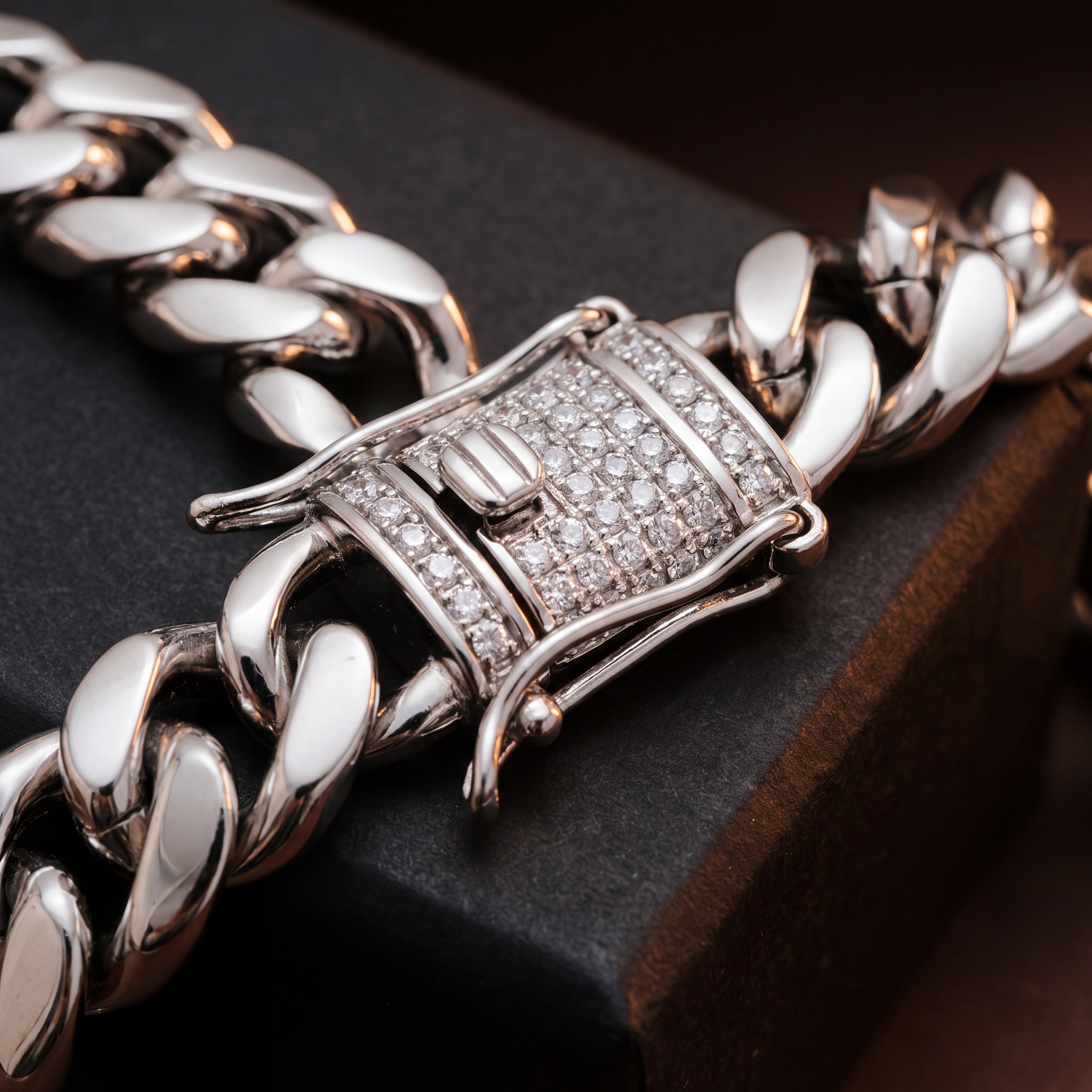 Close-up of the pave cubic zirconia box clasp on a plain stainless steel Cuban link bracelet